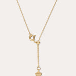Gold necklace with a unique pendant on a light beige background