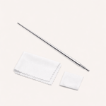 The Vanchi Labret Piercing Taper Care Set, featuring a metal taper with textured grip, is shown above a folded white cloth and small square pad on a light surface.