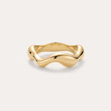 The Vica Fluid Wave Chunky Band Ring in Gold features a bold, wavy band design and is displayed on a simple, light background.
