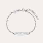 The Viva La Vida Bar Chain Bracelet in Silver features an adjustable Figaro chain, a rectangular plate engraved with VIVA LA VIDA, and a small embossed logo tag. Pair it with our Viva La Vida necklace for a matching set.