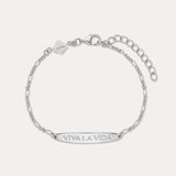 The Viva La Vida Bar Chain Bracelet in Silver features an adjustable Figaro chain, a rectangular plate engraved with VIVA LA VIDA, and a small embossed logo tag. Pair it with our Viva La Vida necklace for a matching set.
