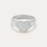The Willa Heart Signet Pinky Ring in Silver features a smooth, heart-shaped face with a delicate textured border—ideal as a sterling silver pinky ring and beautifully presented on a plain light background.