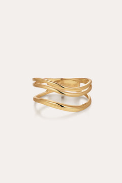 The Zoe Triple Wave Ring in Gold features three slim, wavy gold-plated bands intertwined for a modern, elegant look against a plain light background.